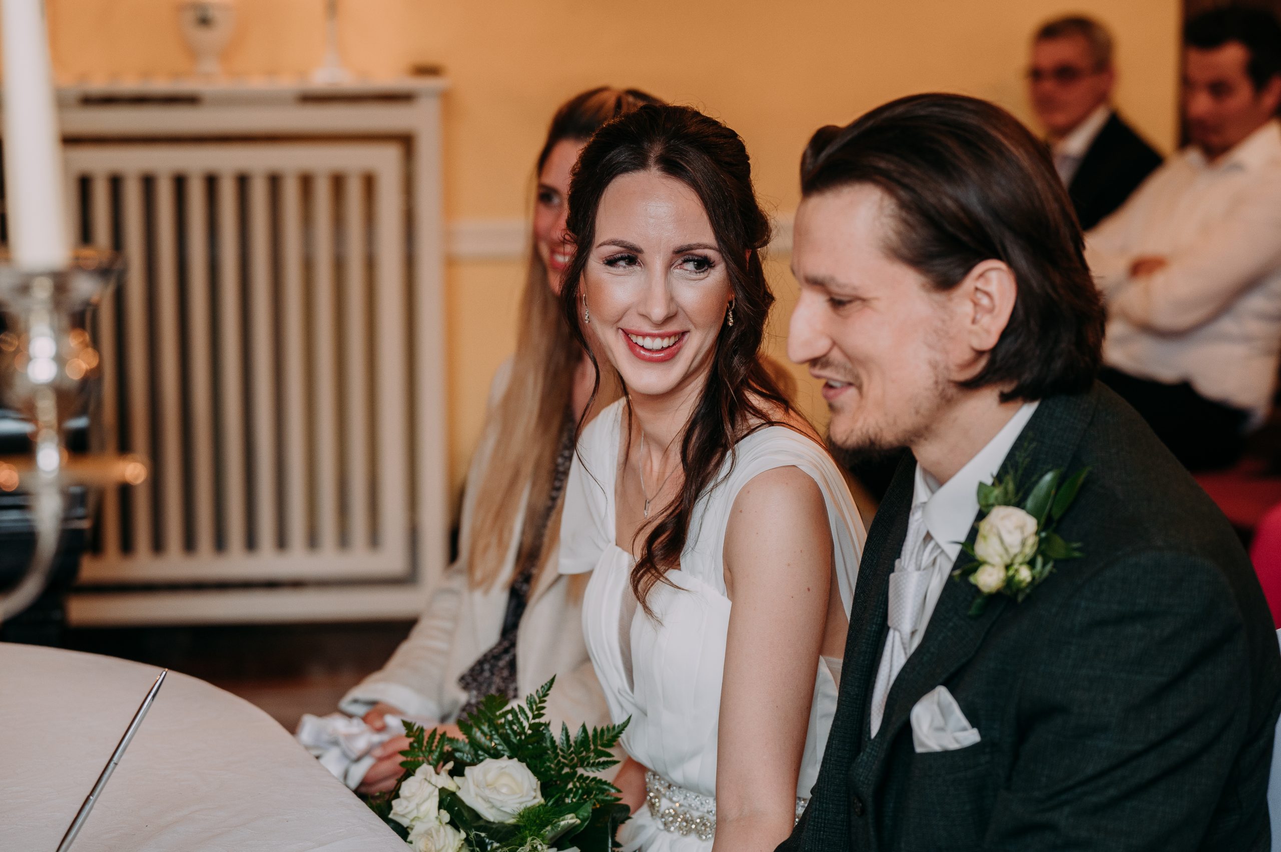 detailfoto waehrend standesamtlicher Trauung, Frau strahlt den braeutigam an dokumentarischer Stil