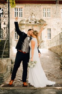 Brautpaar-kuesst-sich-jubelt-schloss-brautpaarfotos