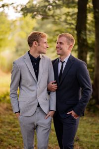 zwei maenner im Anzug heiraten mit Segen unter freiem himmel