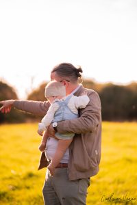 Familienfoto mit Papa der Tochter Baby auf dem Arm haelt