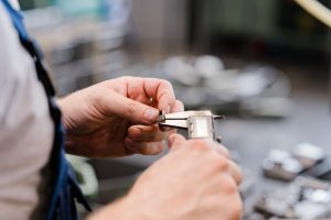 mann misst hergestellte schraube detailfoto mit tiefem bokeh